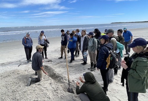 instructor teaching students about beach geology
