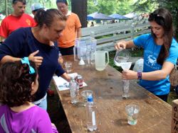 VIMS Ph.D. student Jessie Turner (R) helps guests build a Cartesian diver to learn about bouyancy.