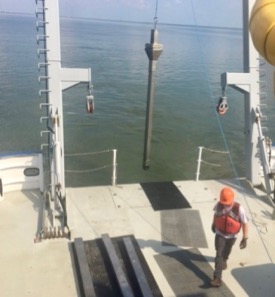 Taylor Moore, mate aboard the R/V {em}Virginia{/em}, assists in deployment of a sediment core to test for chlordecone breakdown products in the James River. ©John Olney, Jr./VIMS.