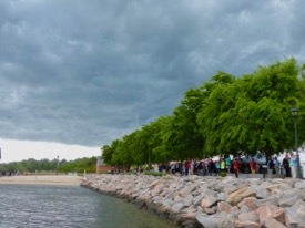 Invited guests and passersby applaud the christening from the shelter of the Yorktown shore as a storm front moves by. © D. Malmquist/VIMS.