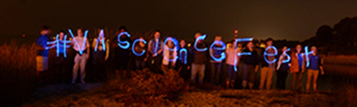 Beach Night participants spell out the official hashtag for the Virginia Science Festival using glow sticks. Photo by Susan Maples-Luellen.
