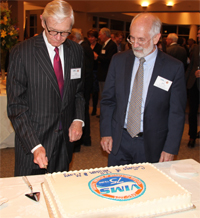 William & Mary President Taylor Reveley (left) and VIMS Dean and Director John Wells (right) cut a cake bearing the official VIMS 75th anniversary seal during an event at NewMarket Pavilion in Richmond.
