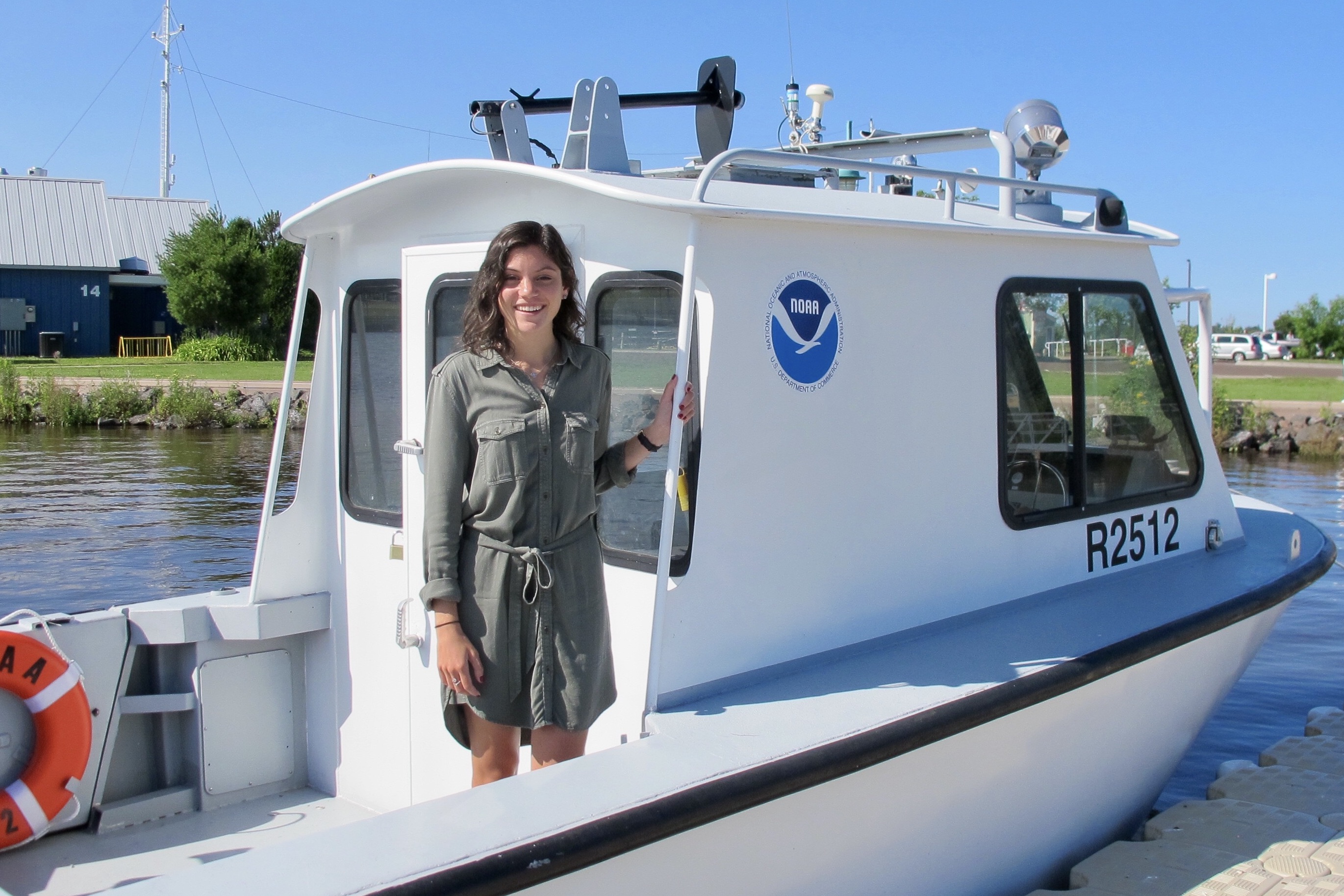 M.A. student Kacey standing on a boat and smiling