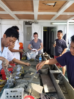 VIMS lab manager Mary Goodwyn (C) joins with Myanmar colleagues aboard the vessel Sea Princess to process a sediment core taken from the Andaman Sea.