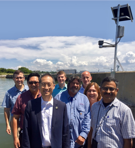 StormSense Project Core Team at Leeward Marina in Newport News at the first StormSense ultrasonic water-level sensor. L to R: Kyle Spencer, Deputy Resilience Officer, Norfolk; Cuong Nguyen, Smart Grid Lead, NIST; Sokwoo Rhee, Associate Director, Cyber-Physical Systems, NIST; Derek Loftis, StormSense Project Manager, Research Scientist, VIMS; Mike Ashe, Public Works, Newport News; Eric Beach, IT Project Manager, Newport News; Tammie Organski, GIS Manager, IT, Newport News; Sridhar Katragadda, Systems Analyst, Virginia Beach.