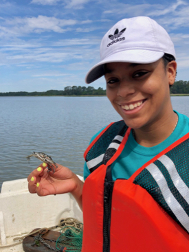 REU student Thalia Wallace enjoys her first encounter with a blue crab.