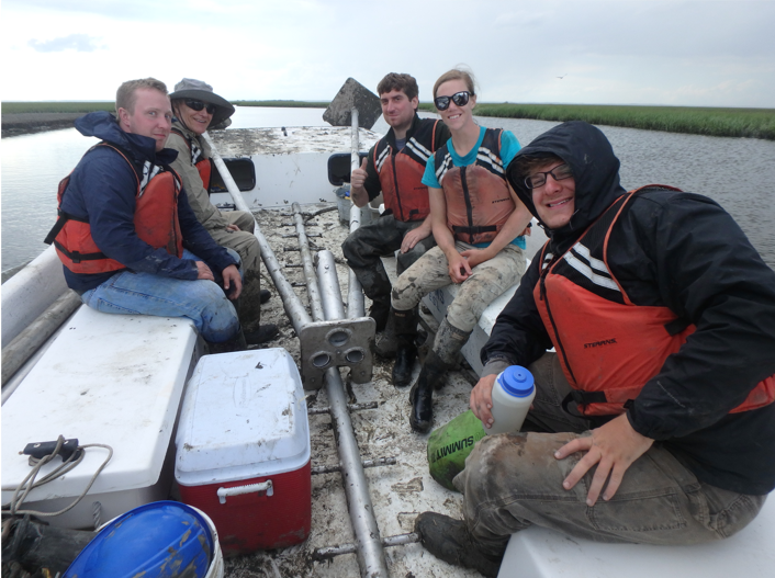 John Harding (2nd from L) assists in a sediment-coring operation with other members of the Coastal Geology Lab at VIMS.