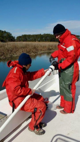Semedo and fellow Ph.D. student Kenneth  Czalpa collect a sediment sample from a tidal creek on Virginia's Eastern Shore. Semedo designed his study to sample during all seasons, including the chill of winter. © S. Fate/VIMS ESL.