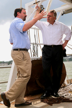 Latour describes the importance of fish-monitoring programs to then-Governor Terry McAuliffe aboard the RV {em}Bay Eagle{/em} in this 2014 photo. © Michaele White/VA Governor's Office.