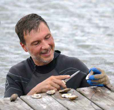 Dr. Bill Walton examines a farmed oyster. © Auburn University College of Agriculture.