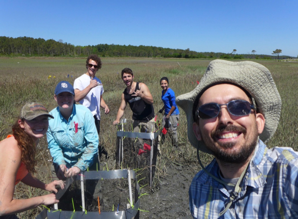 Dr. David Johnson (R) conducts fieldwork in a Virginia saltmarsh with members of his lab team.