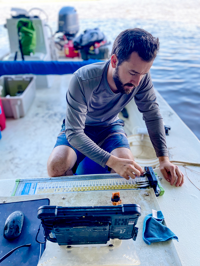 Scientist Jack Buchanan measures juvenile striped bass on the Pamunkey River. © Samantha Dowiarz/VIMS.