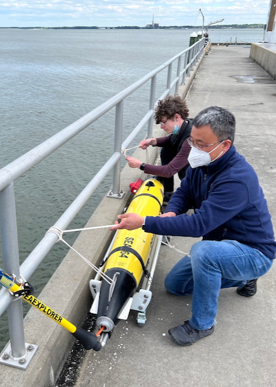 W&M undergrad Jack Slater ’22 (background) prepares to run a dry-dock test on an autonomous underwater vehicle from the lab of VIMS professor Donglai Gong (foreground).