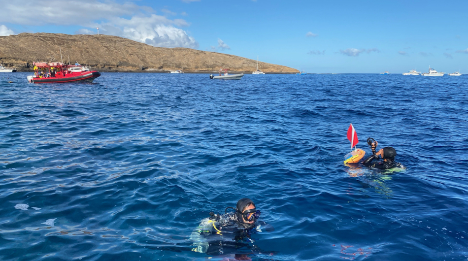 SCUBA divers finish a fish survey while tour boats bob inside the wall of Molokini Crater. © K. Weng/VIMS.