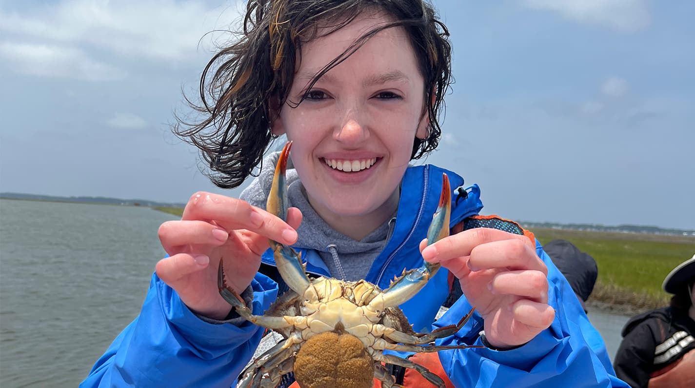 W&M undergraduate student holds a blue crab found during a field class at VIMS' Eastern Shore Laboratory