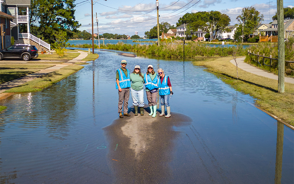 Catch the King volunteers standing in a flooded Norfolk street. Photo by Sue Mangan.