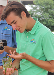 Drew Bostick, star of the Aqua Kids TV Series, examines seagrass while filming at VIMS.