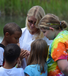 VIMS outreach educator Kattie McMillan shows members of the local Boys and Girls Club how periwinkle snails farm algae on cordgrass. Photo by Susan Maples.