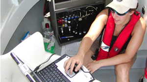 VIMS graduate student Candace Spier operates the computer and biosensor (back left) aboard a research vessel on the Elizabeth River. Photo by Mike Unger.