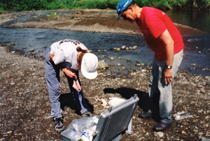 Professor John Milliman (R) prepares to sample the chemistry and sediment load of a small mountain river.
