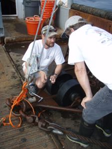 VIMS scientists David Rudders and Roger Mann prepare to retrieve a scallop dredge while aboard a commercial fishing vessel.