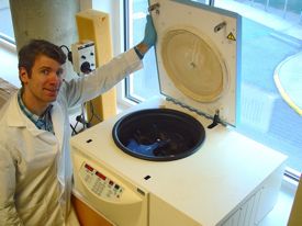 Assistant Professor Andrew Wargo with a centrifuge donated by Altria.