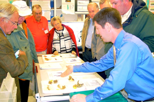 Jim Gartland (forefront) shows members of the Virginia Marine Resources Commission how fish ear bones can be used like tree rings to determine a fish's age.