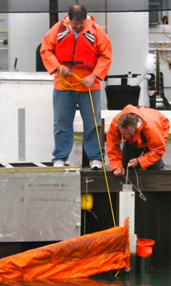 Mr. Raymond Forrest (standing) takes part in a VIMS oil spill response drill.