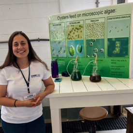 Algologist Amanda Chesler-Poole at her algae station on Marine Science Day.  She uses this display to teach VIMS campus visitors about the imporance of nutrition in raising healthy oysters in the hatchery.  