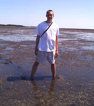 A VIMS intern stands in the middle of an algal bloom on Virginia's Eastern Shore